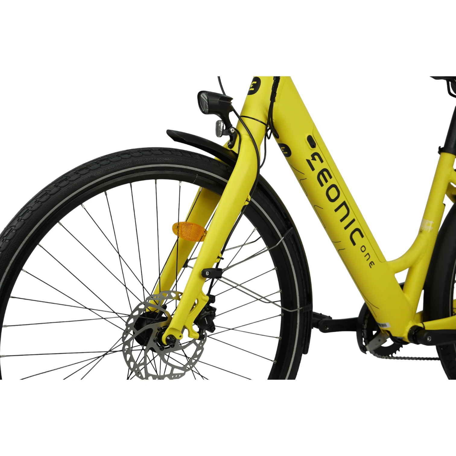 E-Bikes kaufen – Detailansicht des gelben Eonic One Comfort Limited E-Bikes mit Fokus auf das Vorderrad inklusive Continental-Reifen, hydraulischer Scheibenbremse, LED-Scheinwerfer und dem schwarzen Marken-Schriftzug auf dem Unterrohr vor weißem Hintergrund.