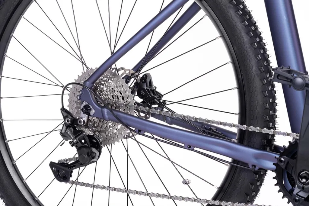 E-Bike Wartung: Schmierung der Kette und Überprüfung der Reifen an einem gelben Fahrrad