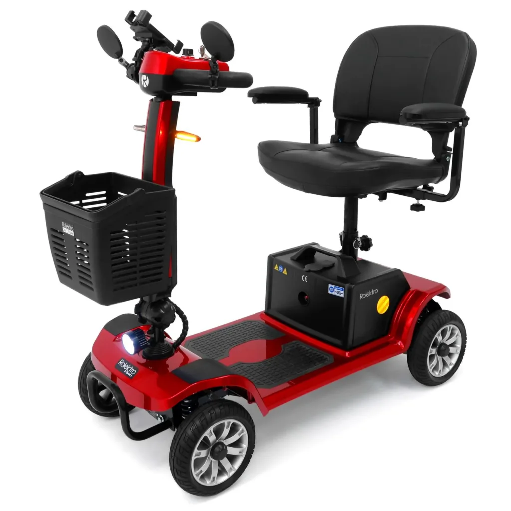 Rolektro kaufen: Perspektivische Frontansicht von links des roten Seniorenmobils Rolektro E-Quad 6 V.2 Pro Bleigel mit leuchtendem LED-Zusatzscheinwerfer und eingeschalteten orangefarbenen Blinkern.