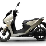 Horwin kaufen: Moderner E-Roller Horwin SK3 Plus der 125er Klasse von der linken Seite fotografiert im eleganten hellen Farbton mit schwarzer Sitzbank und sportlichen Alufelgen.