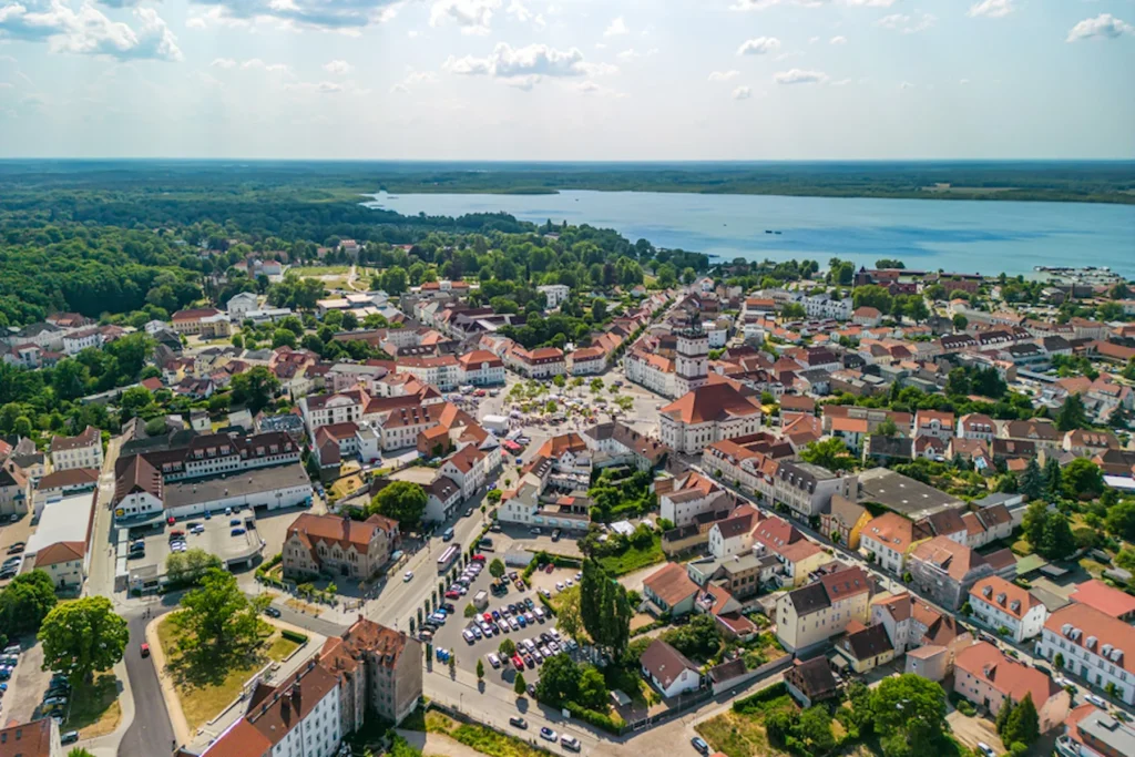 E-Bikes kaufen in Neustrelitz: Luftaufnahme der historischen Residenzstadt Neustrelitz mit dem Marktplatz, der Stadtkirche und dem angrenzenden See.