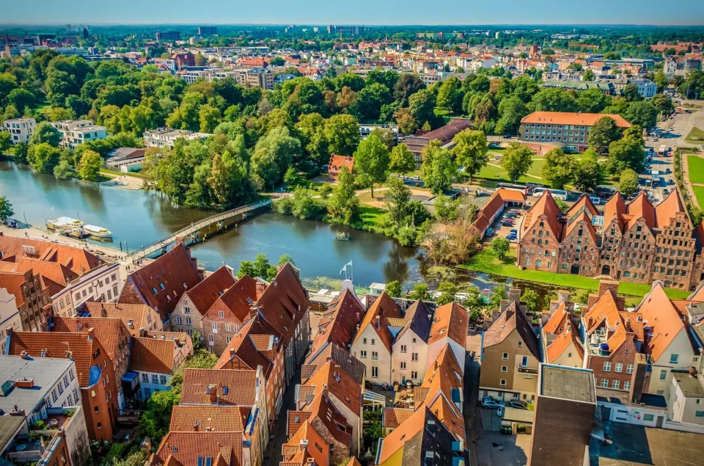 E-Bikes kaufen in Lübeck: Luftaufnahme der historischen Altstadt von Lübeck mit Blick auf die Trave, die Salzspeicher und die rote Backsteinarchitektur.