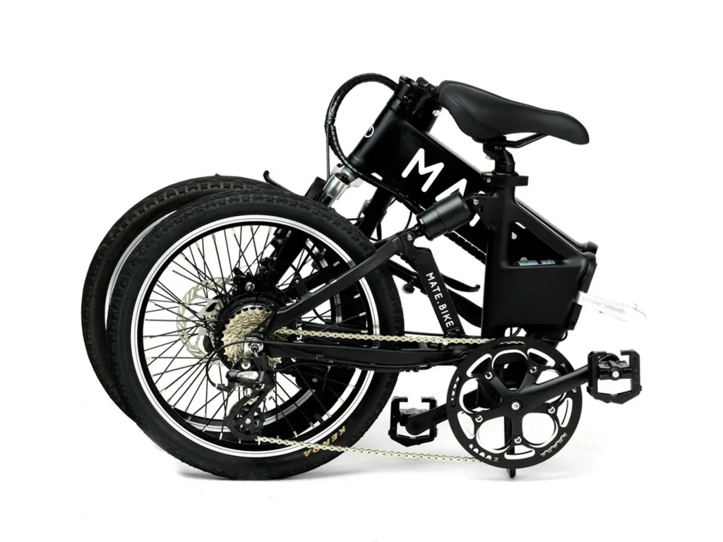 Ein kompakt zusammengeklapptes, schwarzes MATE Klapp-E-Bike freigestellt auf weißem Hintergrund.